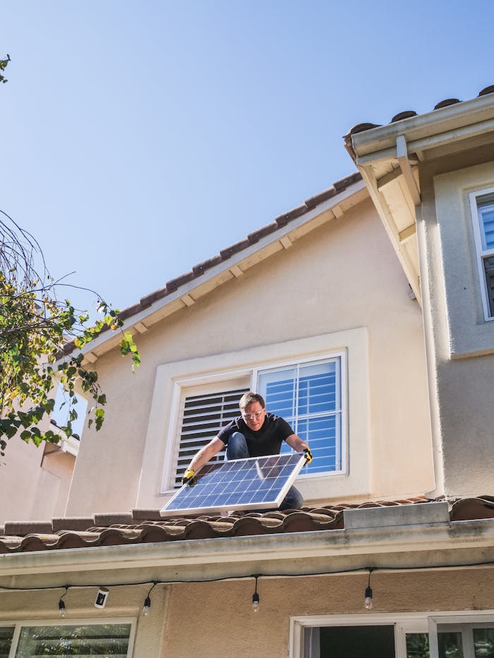 services-02 A worker installs a solar panel on a residential rooftop, showcasing renewable energy technology.